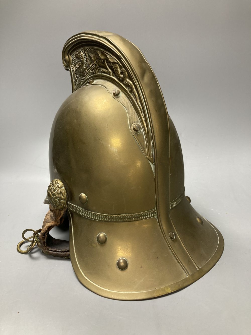 An early 20th century brass firemans helmet, 17cm
